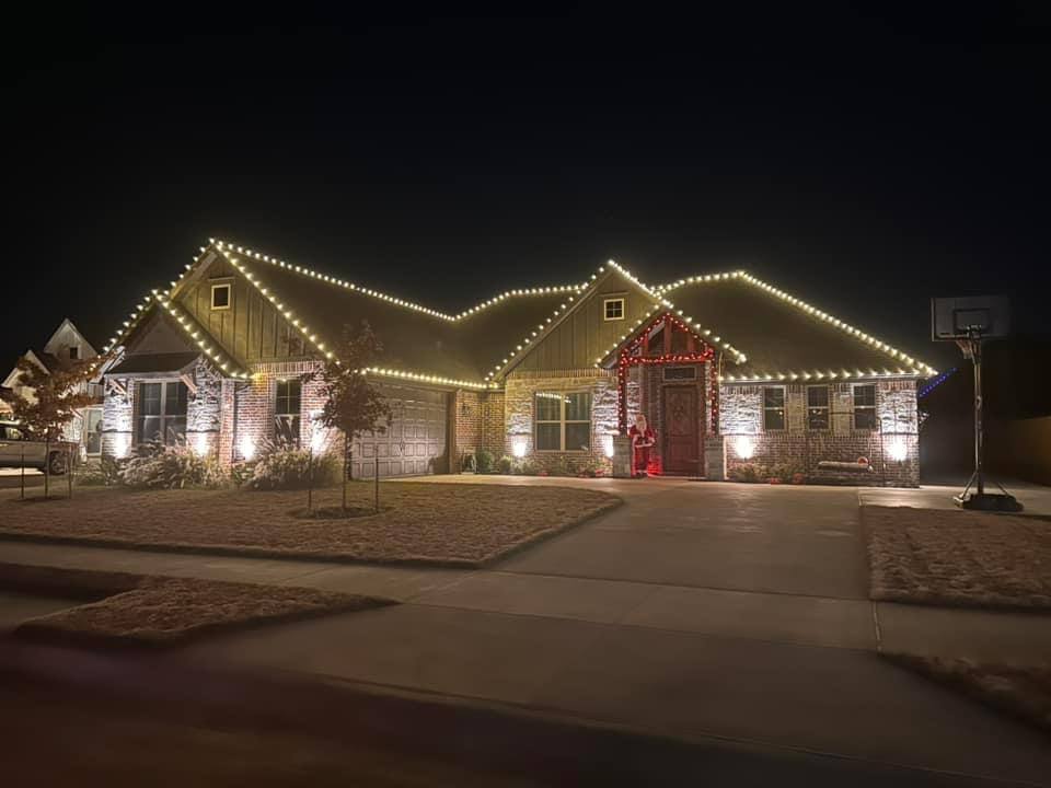 Red C9 lights framing a home's front entry with a lit Santa figure