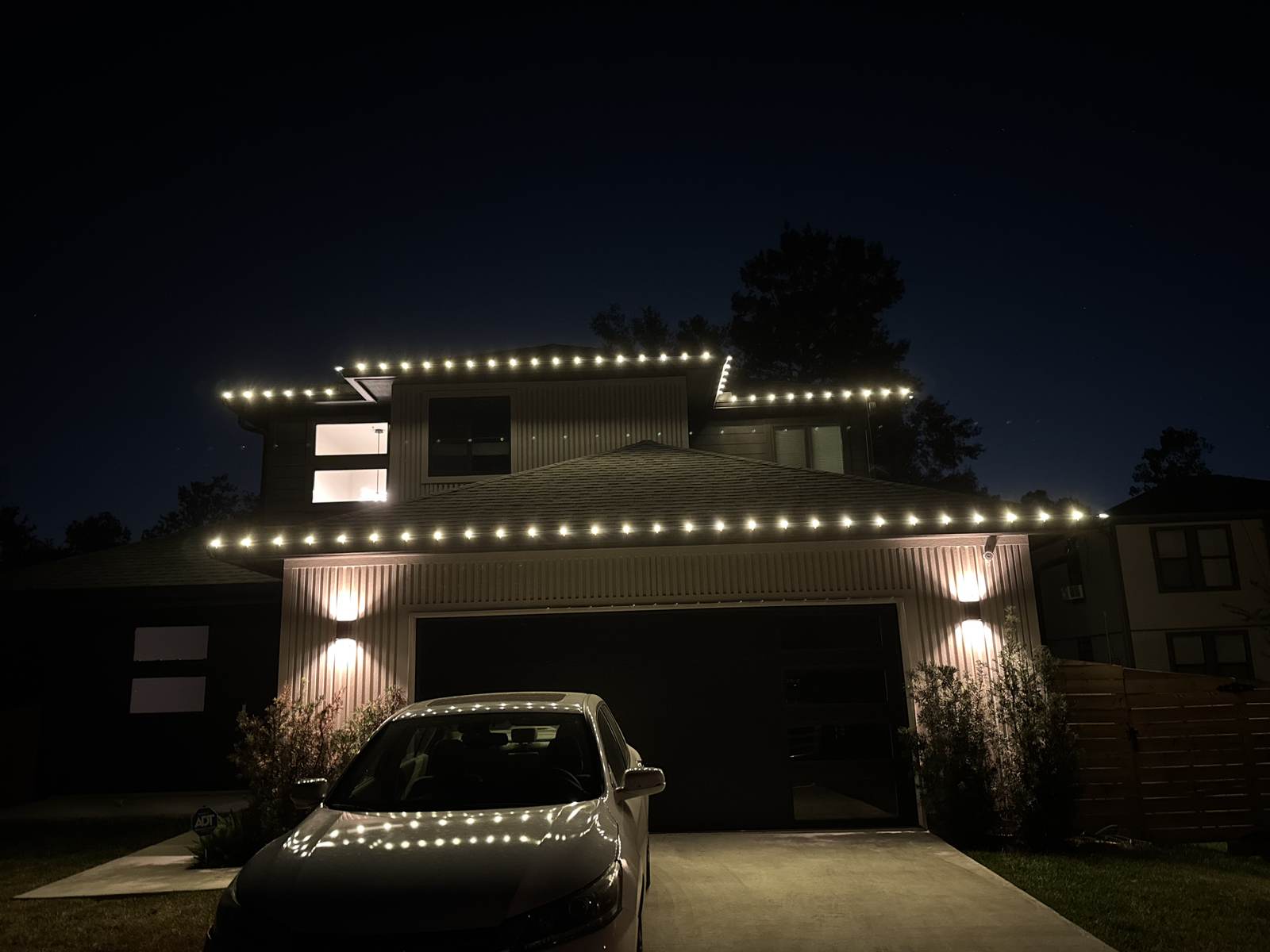 Warm white roofline lighting on a modern two-story home