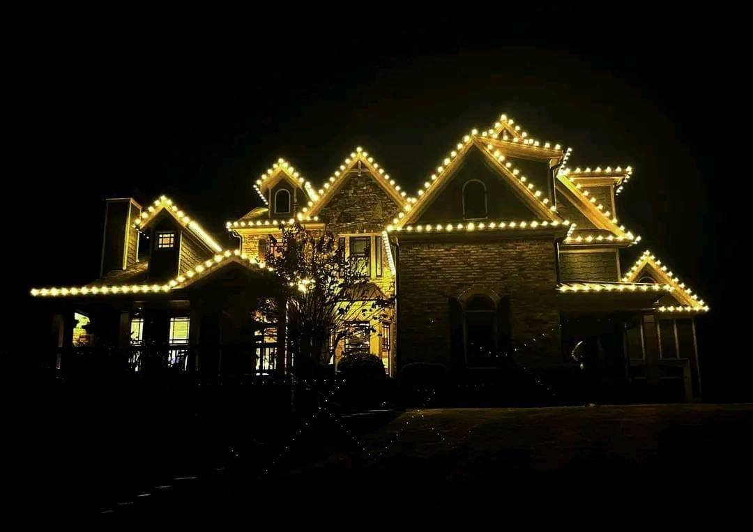 Warm white lighting tracing multiple rooflines and gables against a night sky