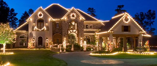 Warm white roofline lighting with wreaths on a stucco home